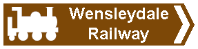 brown sign pointing to Wensleydale Railway